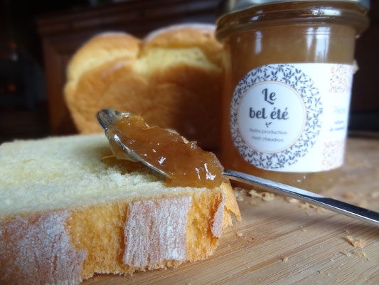 Photo d'un pot de confiture le bel été avec une cuillère remplis de cette confiture